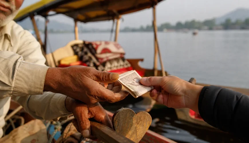 A tourist handing rupee notes to a Kashmiri shikara boatman on Dal Lake, an example of normal tipping in Kashmir