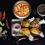 Tandoori meat and curry dishes with spices, representative of a Kashmiri Wazwan feast course