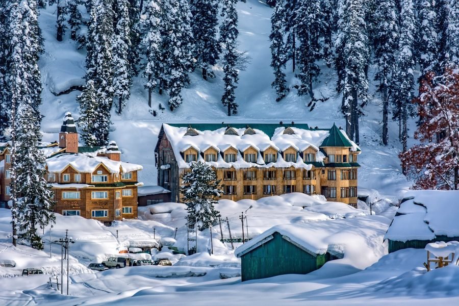 Wooden hotel buildings covered in deep snow among pine trees in Gulmarg Kashmir