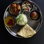 A traditional Indian thali plate with curry, rice and roti served at a restaurant
